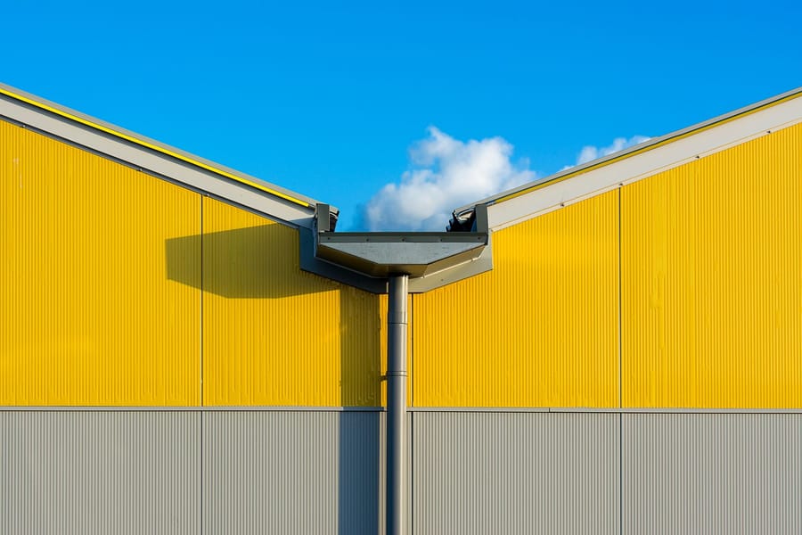 A gutter and downspout on the corner of a building